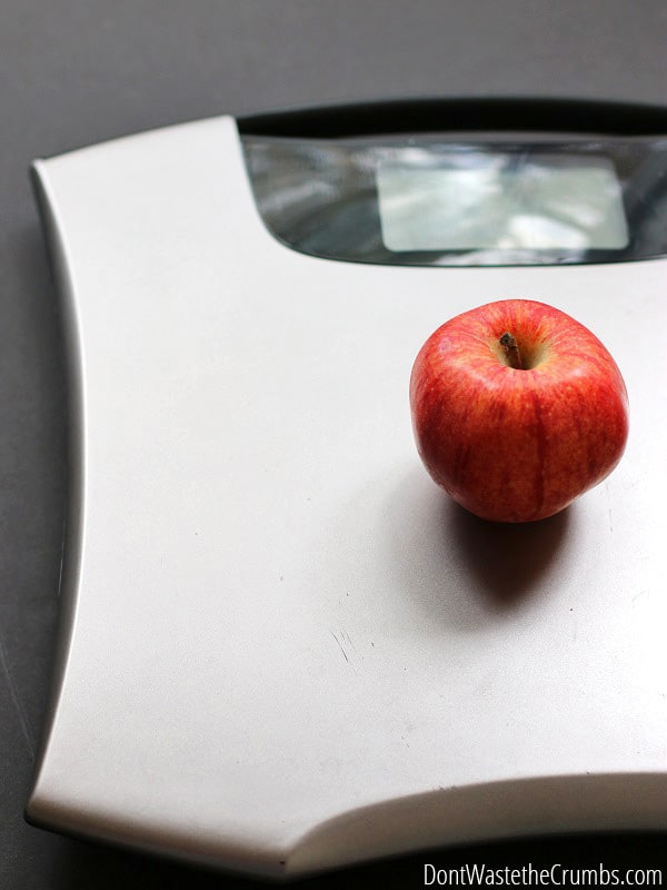 A weight scale with an apple on it.