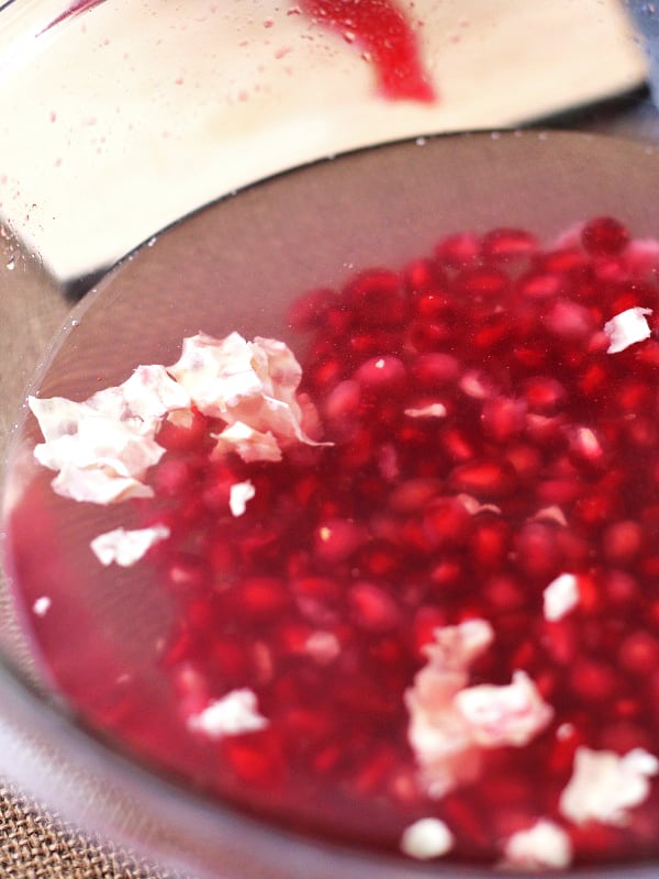 Rinse and drain the water from the pomegranate seeds after you have separated the white membranes. Store the pomegranate arils in a container lined with a paper towel. 