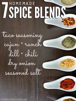 Six white stylish spoons, each filled with rich colored spice, all on a dark wooden table. Text overlay 7 Homemade Spice Blends - Taco Seasoning - Cajun - Ranch - Dill - Chili - Dry Onion - Seasoned Salt.
