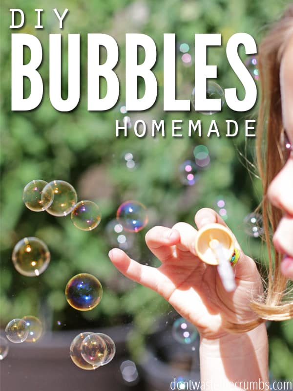 Image of child blowing bubbles out in the woods. Learn how to make liquid bubbles! Text overlay reads, "DIY Bubbles Homemade".