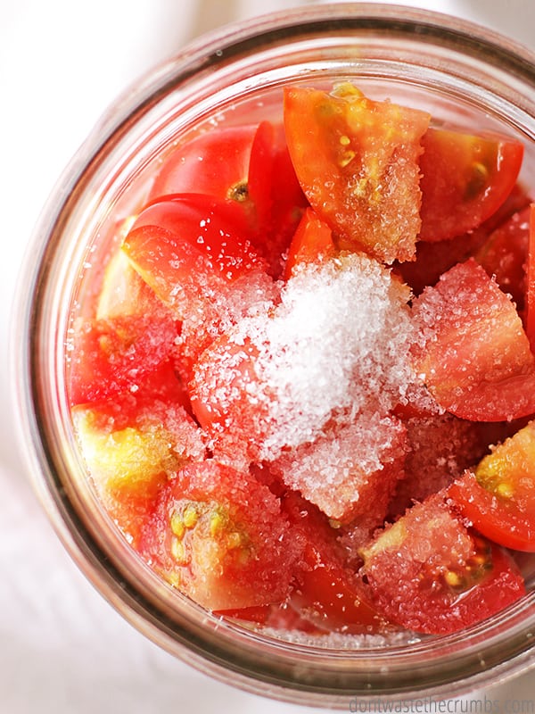 Diced tomatoes in a canning jar and salt on the top
