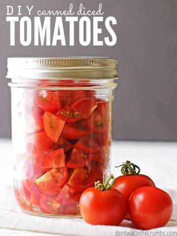 Mason jar with canned diced tomatoes and a few fresh tomatoes sitting in front of it. Text overlay says, "DIY Canned Diced Tomatoes".