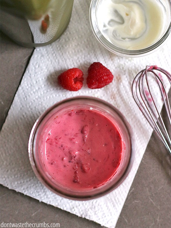 A glass jar of smoothie and a whisk next  to it.