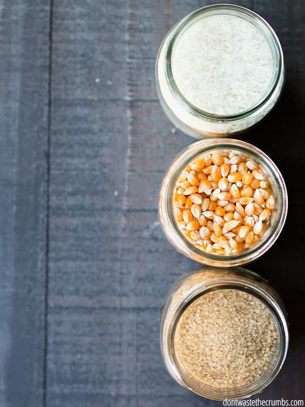 One mason jar has salt, the other mason jar has popcorn kernels, and the other mason jar has rice grains.