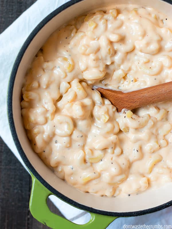 Pot of creamy mac & cheese with a wooden spoon.