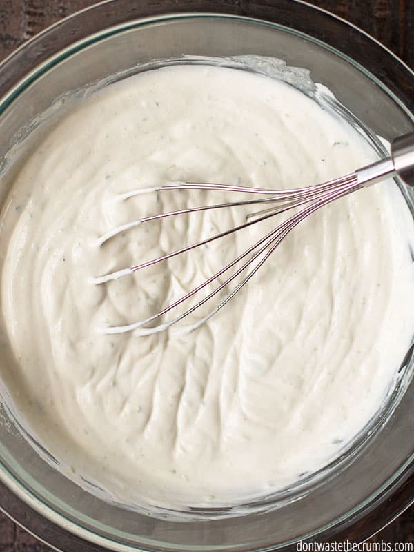 Homemade lime crema in a small bowl with a whisk.