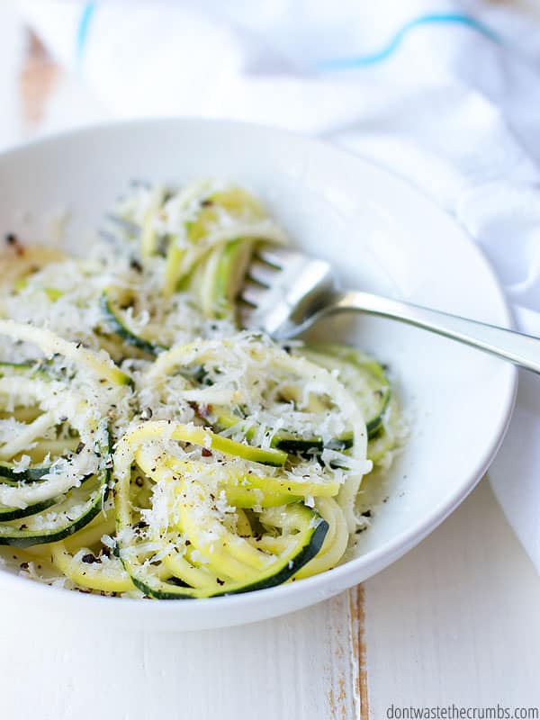 Bowl of zoodles tossed with Parmesan cheese.