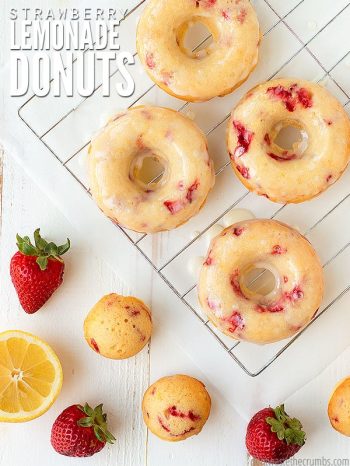 Homemade donuts sitting on a cooling rack, drizzled with glaze. Text overlay says, "Strawberry Lemonade Donuts"