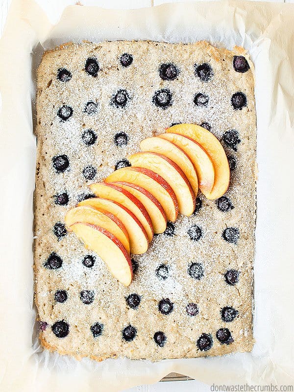 Sheet pan pancakes are fast and easy for a busy morning! This is all ready in the baking sheet and has sliced apples as a topping and blueberries throughout.