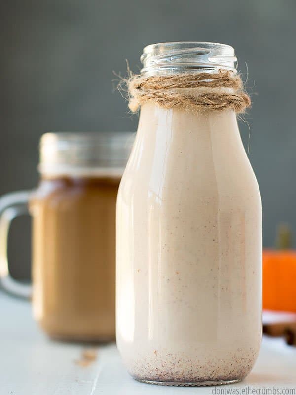 Pumpkin spice coffee creamer in a glass bottle in front of a glass of coffee. Made with homemade pumpkin pie spice, and much healthier than the powder!
