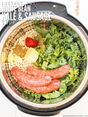Overview of an Instant Pot, filled with white beans, sausage, spices and greens. Text overlay Instant Pot White Bean Kale & Sausage Soup.
