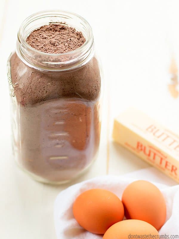 This homemade chocolate cake mix recipe is all done and sitting in a quart size glass mason jar. Beside the mix are 3 eggs and butter. These are the rest of the ingredients that you will need to make a chocolate cake or cupcakes.