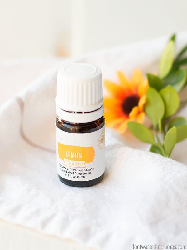 Four amber colored essential oil bottles fading into the background with a yellow flower in the foreground. Text overlay 50+ Ways to use Essential Oils Without Diffusing.