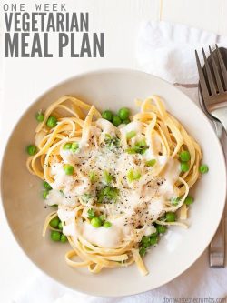 Overview of a white bowl filled with cooked pasta topped with cream sauce and peas. Text overlay One Week Vegetarian Meal Plan.
