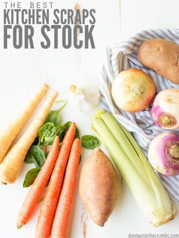 Various carrots, celery, garlic and sweet potato scraps sitting on a whitewashed wooden kitchen table. Text overlay The Best Kitchen Scraps for Stock.