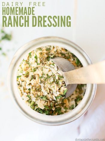 Overview, close up look into a Mason jar filled with minced parsley, salt, dried dill and other spices. Small scoop spoon sits in the jar.Text overlay Dairy Free Ranch Dressing.