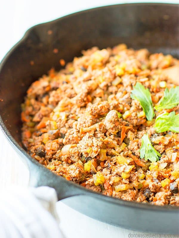 Stretched ground beef taco meat. With lentils, carrots, mushrooms and celery in a cast iron skillet.