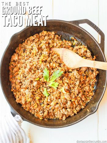 Overview of a cast iron skillet filled with cooked ground beef. Green leaf garnish and a wooden spoon ready to dish up a portion. Text overlay The Best Ground Beef Taco Meat.