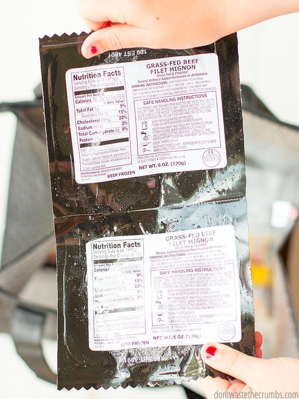 Hands holding the backside of meat packages showing the nutritional facts and safe serving standards.