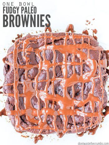 Huge brownie with chocolate sauce drizzled in a criss-cross pattern. Text overlay One Bowl Fudgy Paleo Brownies.
