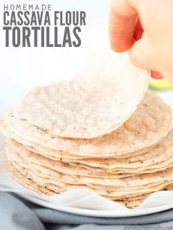 Stack of tortillas with a woman's hand lifting one up. Text overlay says, "Homemade Cassava Flour Tortillas".
