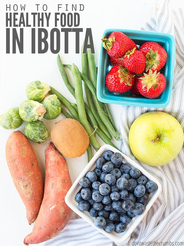 Carton of blueberries, carton of strawberries, sweet potatoes, a kiwi, brussel sprouts and green beans on a white table. Text overlay How to find Healthy Food in Ibotta. 