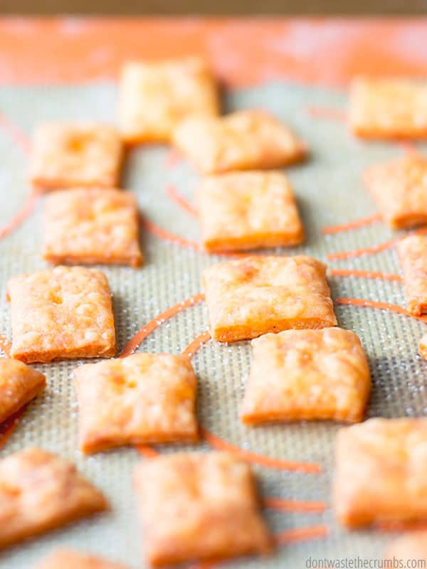 Homemade fresh cheez-its on a cookie sheet with a Silpat mat