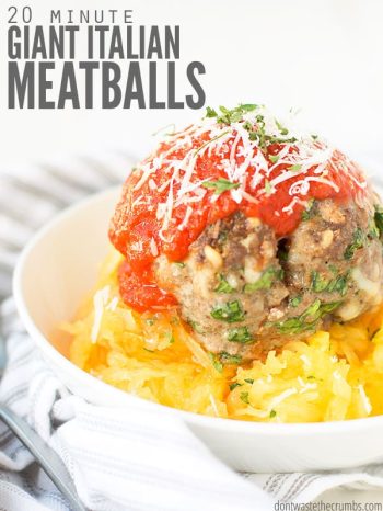 A white bowl of shredded spaghetti squash, topped with a giant meatball and pasta sauce. Text overlay says, "20 Minute Giant Italian Meatballs".