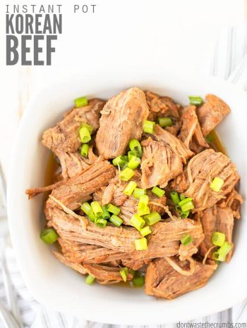 Bowl of shredded korean beef with green onions sprinkled on top. Text overlay says, "Instant Pot Korean Beef".