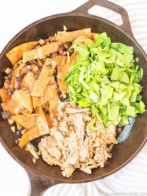 Lettuce, cooked chicken, corn tortillas, mushrooms, and onions in a pan soon to be combined to make a delicious meal. The image is taken from a birds-eye view.