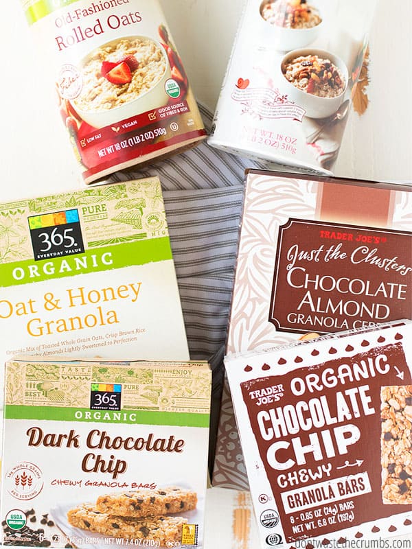 Trader Joe's boxed products: Dark chocolate granola bars, oat and honey granola, chocolate almond granola cereal, and organic chocolate chip granola bars, two containers of rolled oats