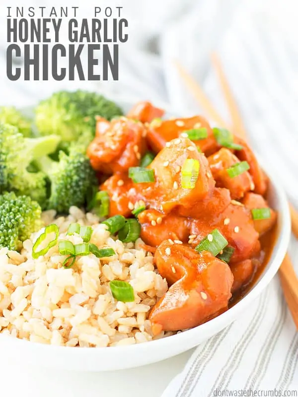 White bowl of hot rice, broccoli and chicken on a table with chopsticks. Text overlay Instant Pot Honey Garlic Chicken.