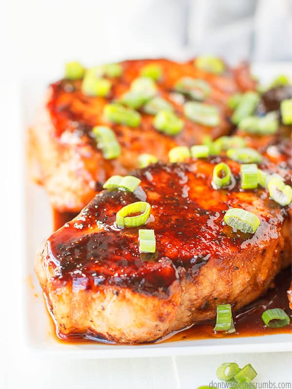 Homemade maple glazed pork chops on a white plate.