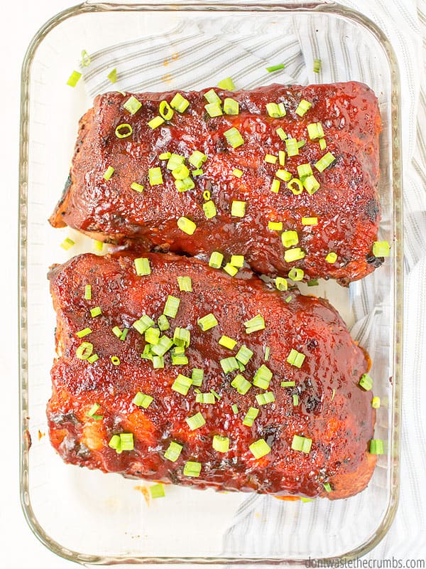 Slow cooker ribs that are done and ready in a glass baking pan!