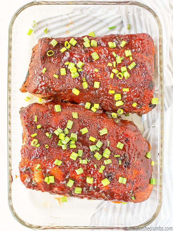 Slow cooker ribs that are done and ready in a glass baking pan.