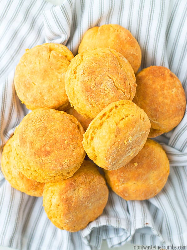 Sweet potato biscuits, cooked to light brown perfection, are piled atop one another. 