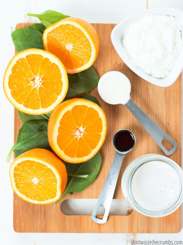 Green Smoothie ingredients with oranges, spinach, vanilla, milk, kefir or yogurt and collagen