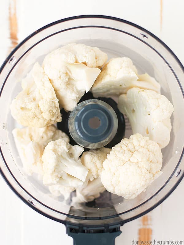 Pictured is an overview of cut up cauliflower in food processor.