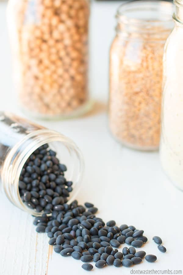 How to batch cook and cook a lot at one time to save for meals later. A jar of black beans and other dried food are in this image.