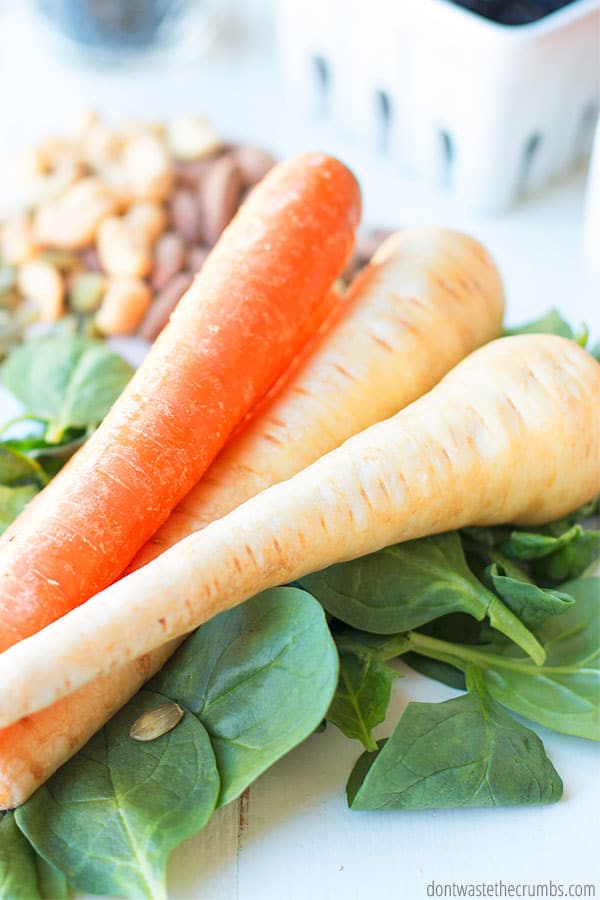 Three carrots on top of some greens