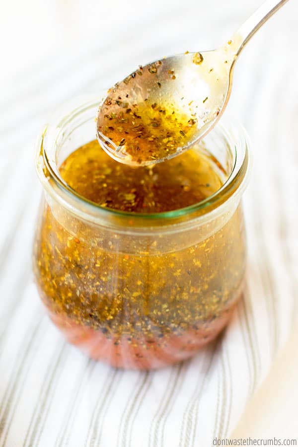 best Greek salad dressing recipe on a spoon over a jar