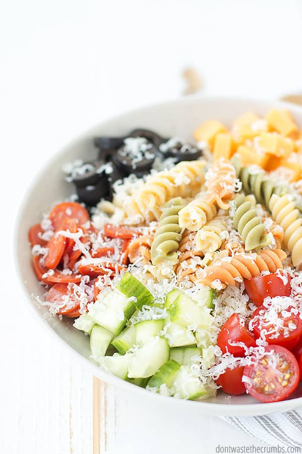 Fresh Italian pasta salad finished with parmesan cheese. This salad has cooked pasta, cheese cubes, olives, cherry tomatoes, cucumbers, sliced pepperoni, sun-dried tomatoes.