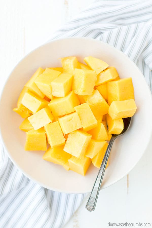 Cubes of mangoes in a white bowl.