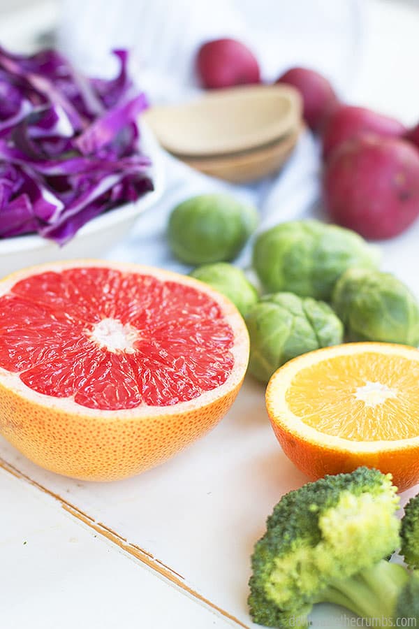supermarket price comparison produce on a table: sliced grapefruit, sliced orange, cabbage, broccoli
