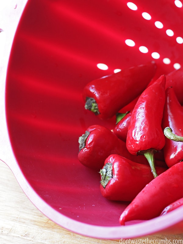 Red strainer with red peppers.