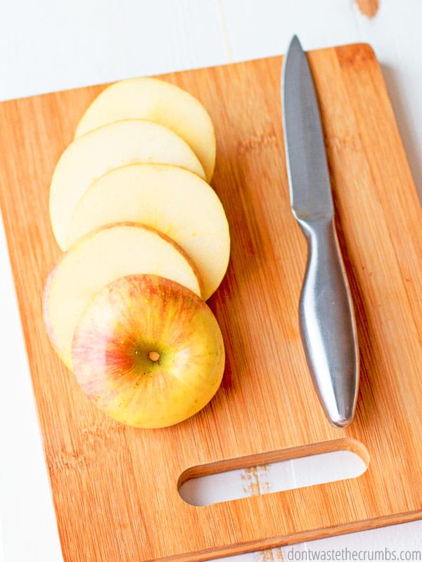 Sliced apples on a cutting board with a knife. 