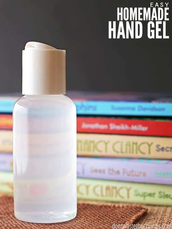 A clear bottle of homemade hand sanitizer with a stack of books behind it. The text overlay reads "Easy Homemade Hand Gel."  
