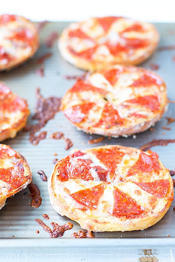 Pizza bagels on a baking sheet.