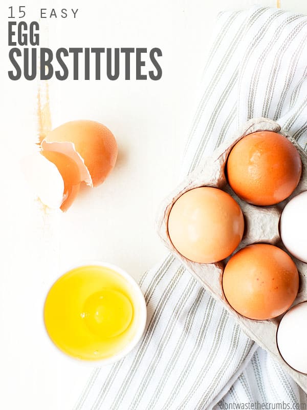 The cover to 15 Easy Egg Substitutes. Shown is an egg shell above a small bowl holding the yolk and egg whites. Off to the side a carton of eggs is placed on top of a striped towel.