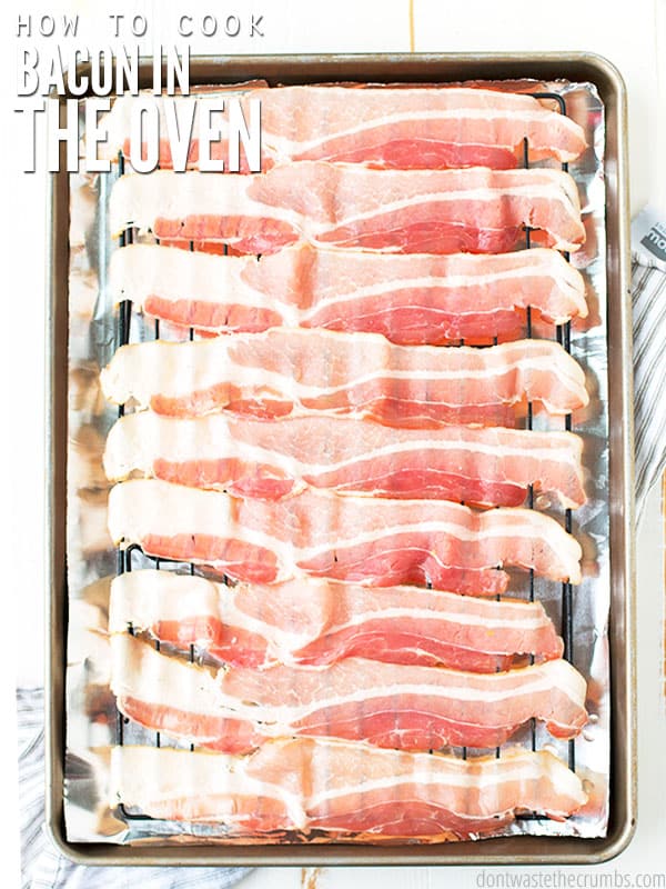 The cover photo on the post, How to Cook Bacon in the Oven. 9 raw strips of bacon are on a wire rack with tin foil and a rimmed cookie sheet under them. 